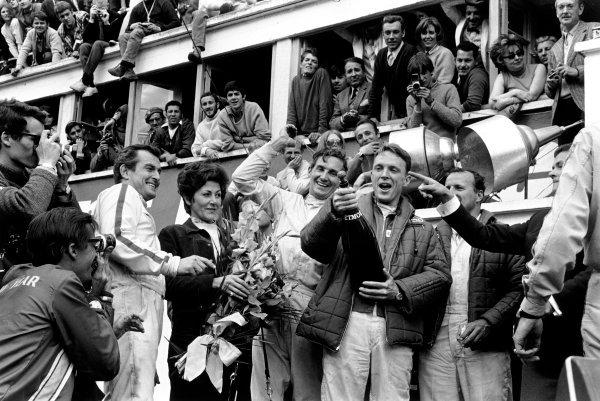 Le Mans, France. 10 - 11 June 1967.Dan Gurney and AJ Foyt (Ford GT40 Mk
IV), celebrate finishing in 1st position with Ludovico Scarfiotti and Mike Parks (Ferrari 330 P4 Coupe), 2nd position, and Jean Marie Dubois of Moet (pointing). This was the first time champagne was sprayed in celebration on a podium at Le Mans, portrait. World Copyright: LAT Photographic. Le Mans, France. 10 - 11 June 1967.Dan Gurney and AJ Foyt (Ford GT40 Mk
IV), celebrate finishing in 1st position with Ludovico Scarfiotti and Mike Parks (Ferrari 330 P4 Coupe), 2nd position, and Jean Marie Dubois of Moet (pointing). This was the first time champagne was sprayed in celebration on a podium at Le Mans, portrait. World Copyright: LAT Photographic.