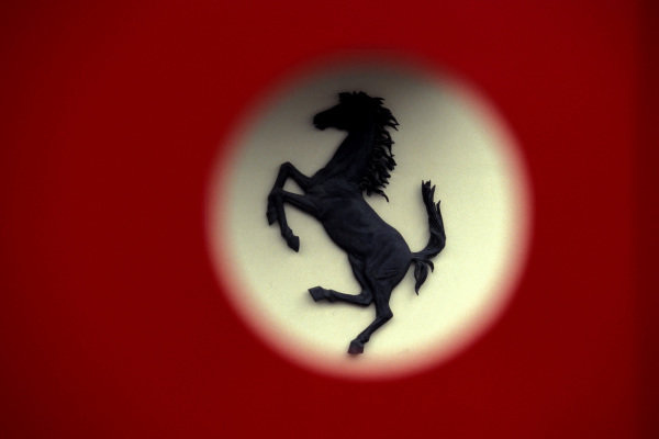 The famous prancing horse logo of Ferrari, seen through a door at the old entrance of Ferrari Sport Management (GES - Gestione Sportiva Ferrari). The famous prancing horse logo of Ferrari, seen through a door at the old entrance of Ferrari Sport Management (GES - Gestione Sportiva Ferrari).